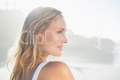 Pretty blonde standing at the beach in white sundress