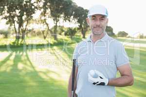 Handsome golfer standing with golf ball