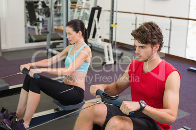 Man and woman working out on the rowing machine
