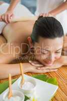 Smiling brunette getting a bamboo massage