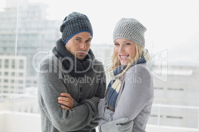 Cute couple in warm clothing smiling at camera