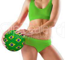 Fit girl in green bikini holding brazil ball