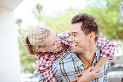 Man giving his pretty blonde girlfriend a piggy back