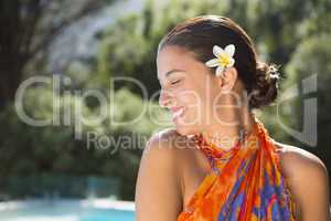 Brunette in sarong smiling by the pool