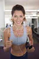 Fit smiling woman running on the treadmill