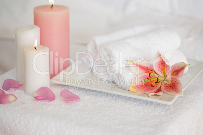 Candles and fresh white towels with lily