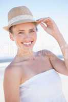 Pretty smiling blonde on the beach wearing straw hat