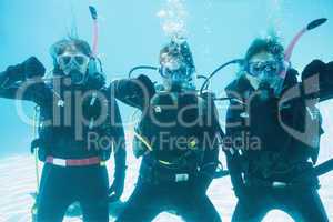 Friends on scuba training submerged in swimming pool showing thu