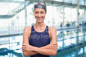 Pretty swimmer smiling at camera by the pool