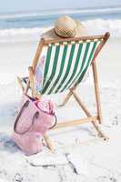 Woman in sunhat sitting on beach in deck chair