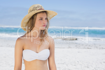 Beautiful blonde on the beach in white bikini and sunhat