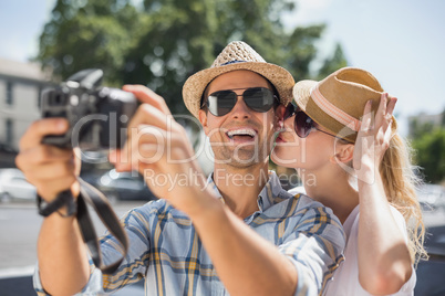 Hip young couple taking a selfie with camera Hip young couple taking a selfie with camera