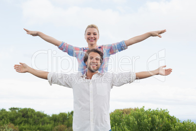 Cute couple standing outside with arms outstretched