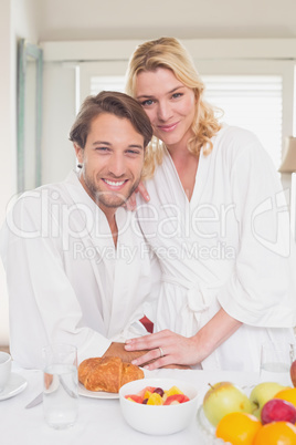 Couple smiling at camera in their bathrobes