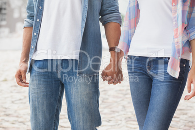 Hip young couple holding hands