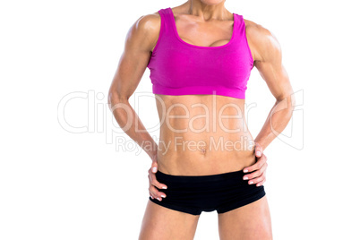 Female bodybuilder posing with hands on hips mid section