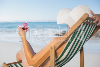 Woman relaxing in deck chair with cocktail