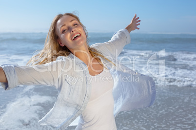 Gorgeous blonde spreading arms out at the beach