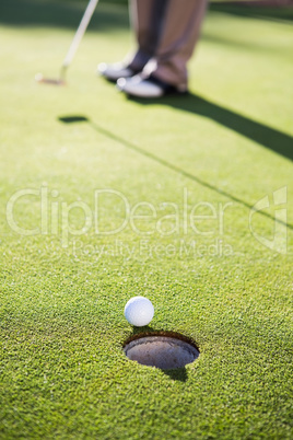 Golfer putting ball on the green