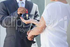 Estate agent giving house key to buyer
