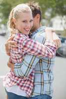 Couple in check shirts and denim hugging each other