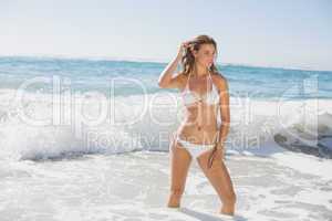 Beautiful smiling woman in white bikini standing in the sea