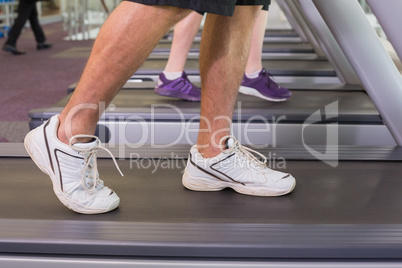 Man and woman walking on treadmills