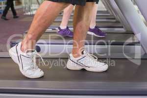 Man and woman walking on treadmills