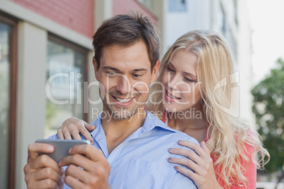 Stylish young couple looking at smartphone