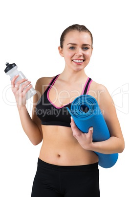 Fit brunette holding mat and sports bottle