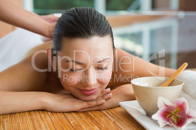 Smiling brunette getting a herbal compress massage
