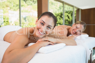 Smiling friends lying on massage tables
