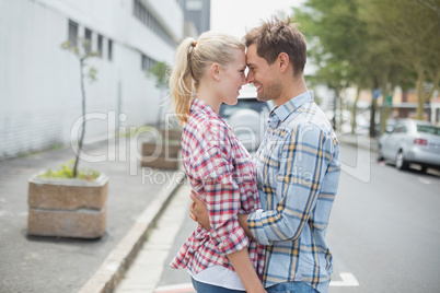 Couple in check shirts and denim hugging each other