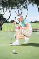 Female golfer watching her ball on putting green