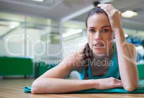 Fit tired brunette lying on studio floor