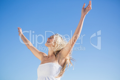 Woman in white dress standing with arms outstretched