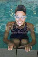 Fit swimmer smiling up at camera in the swimming pool