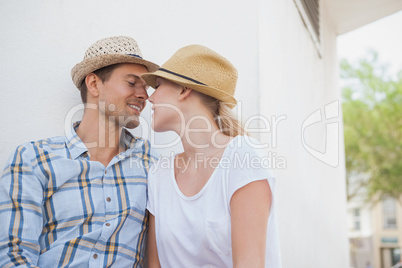 Young hip couple sitting on bench about to kiss