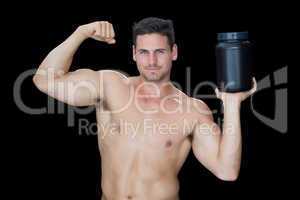 Happy muscular man posing with nutritional supplement