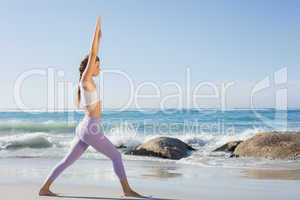 Sporty blonde stretching on the beach