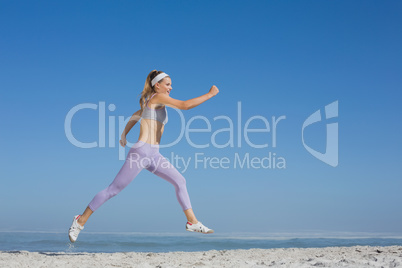 Sporty blonde leaping on the beach