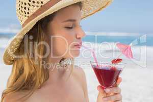 Pretty blonde sipping cocktail on the beach