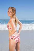 Smiling fit woman in striped bikini at beach