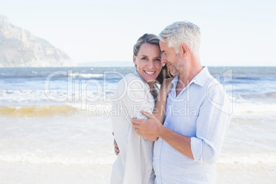 Happy couple hugging on the beach woman looking at camera