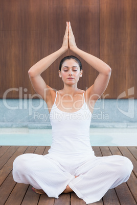 Peaceful woman in white sitting in lotus pose