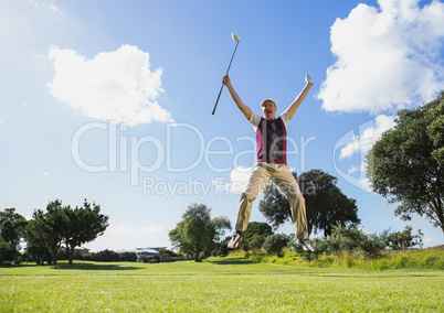 Excited golfer jumping up holding club