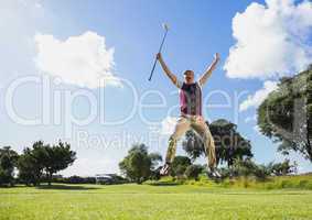Excited golfer jumping up holding club
