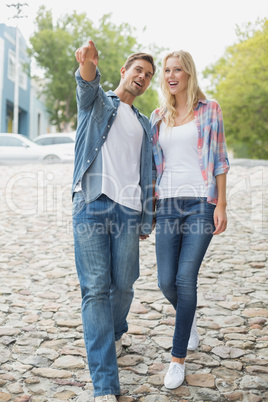 Hip young couple walking holding hands