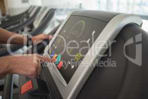 Man adjusting settings on the treadmill