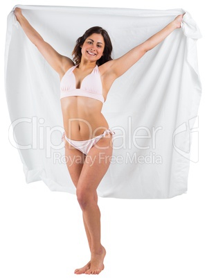 Beautiful brunette in white bikini holding towel